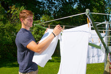 Load image into Gallery viewer, A man hanging clothes on a Deluxe DS9 Sunshine Clothesline